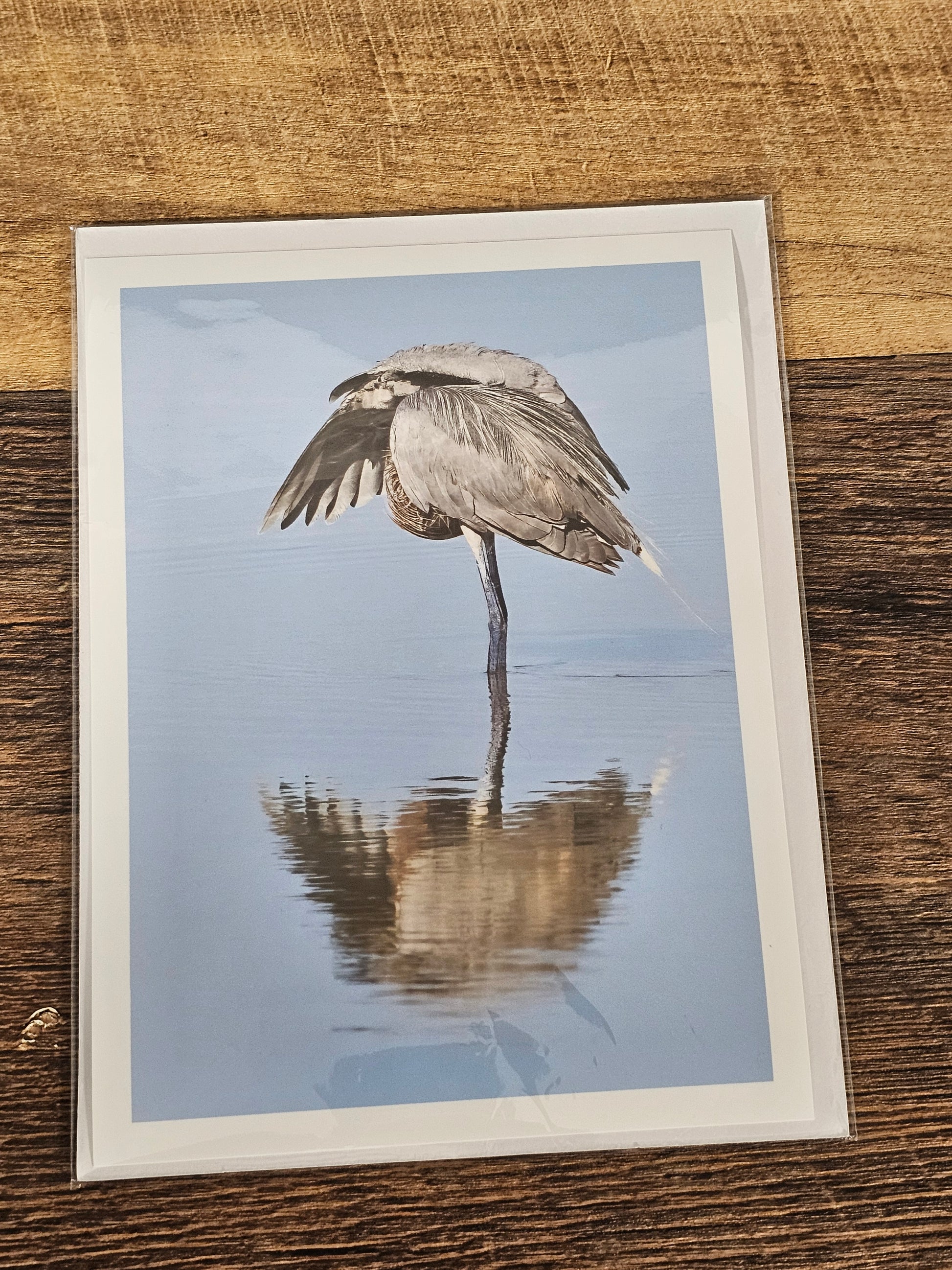 Framed picture of a bird on water with a blurred effect, placed on a wooden surface.
