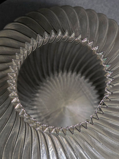 Close-up of the interior of  a translucent gray, ribbed vase  with a textured surface.