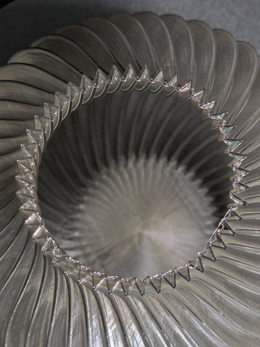 Close-up of the interior of  a translucent gray, ribbed vase  with a textured surface.