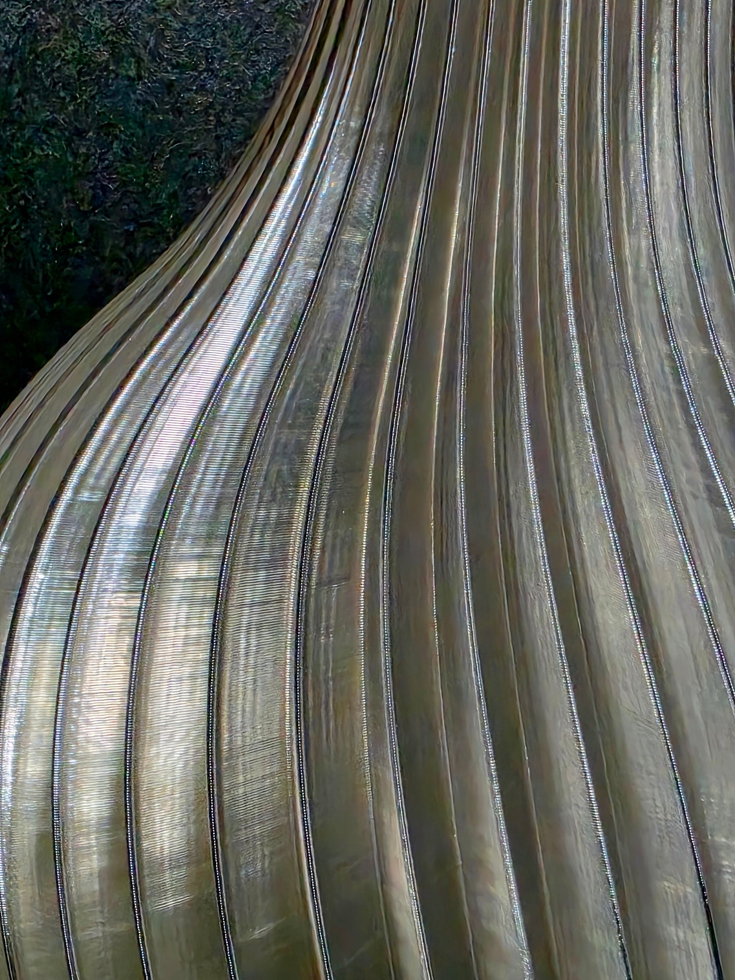Close-up of a translucent gray vase with ribbed texture on a dark background