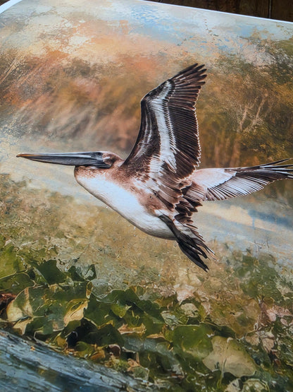 Painting of a pelican flying over water and foliage