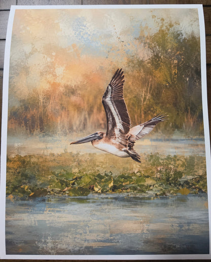 Art print of a pelican flying over water with a natural landscape background