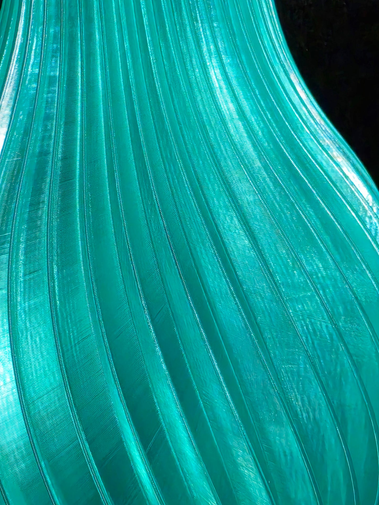 Close-up of teal-colored ribbed plastic vase
