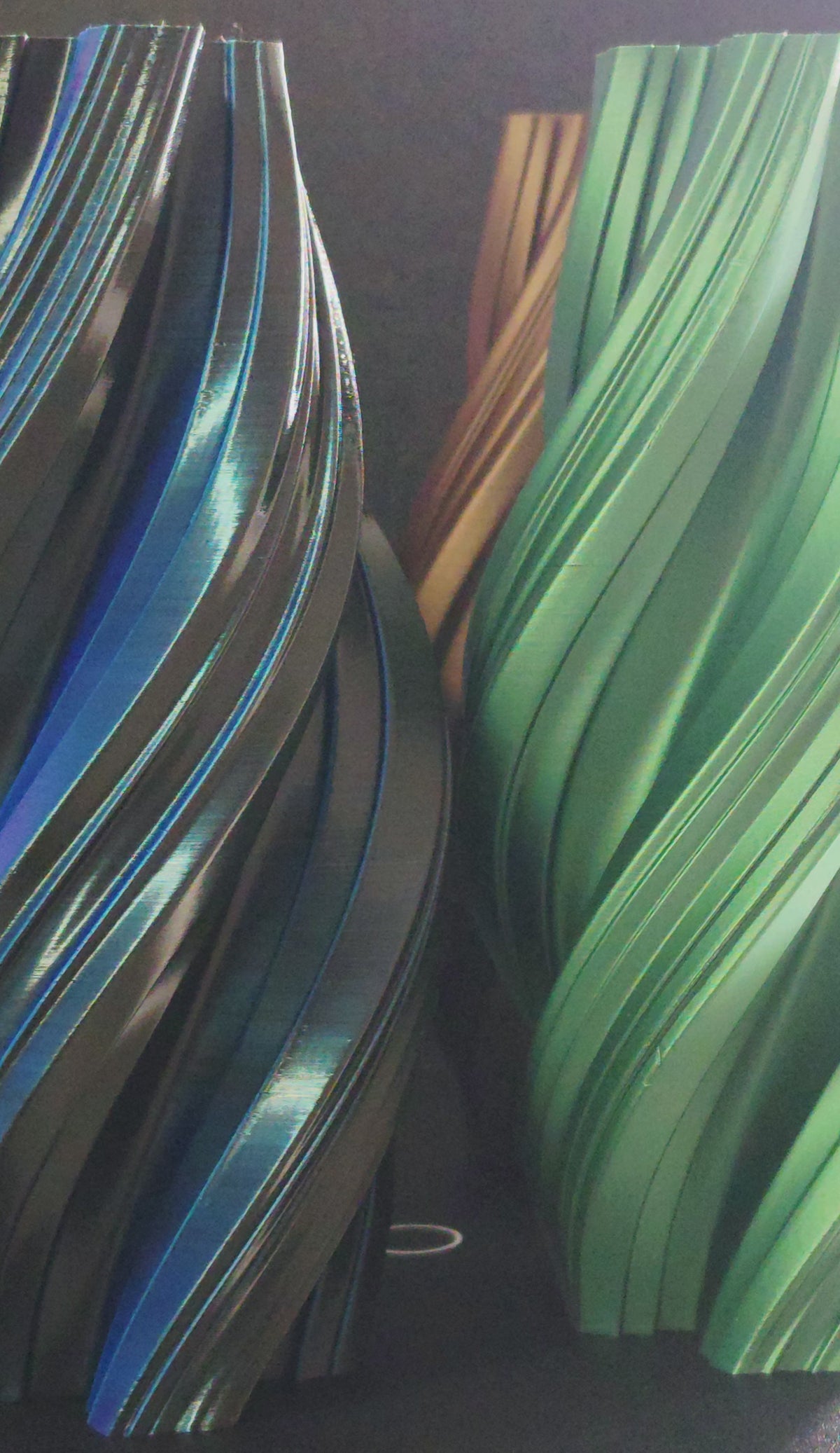 Apex Vases in Bronze, Green, Silver, and Black spinning on turntable display